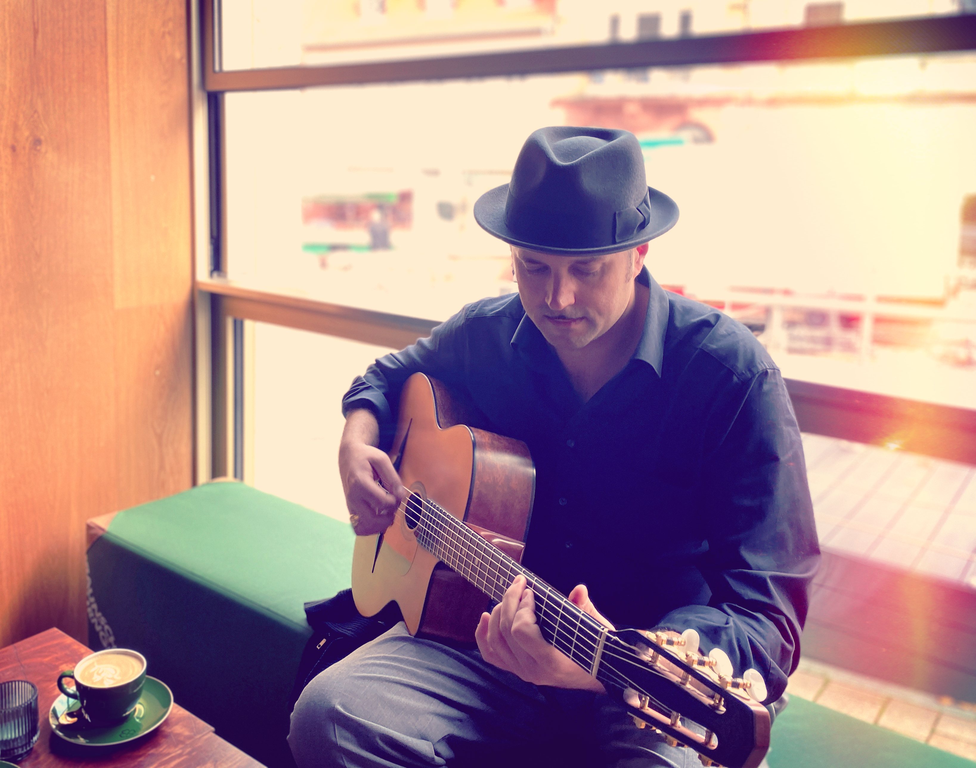 Sebastian Rudolfo Christ spielt Gitarre in einem Café.